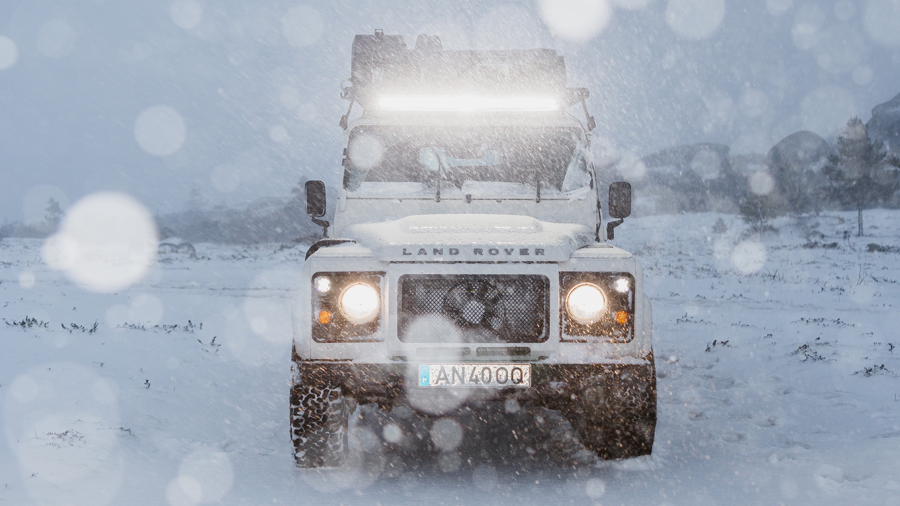 Frontansicht eines Land Rover im Schnee mit Front Runner Dometic LED Light Bar für starke Ausleuchtung bei extremen Winterbedingungen.