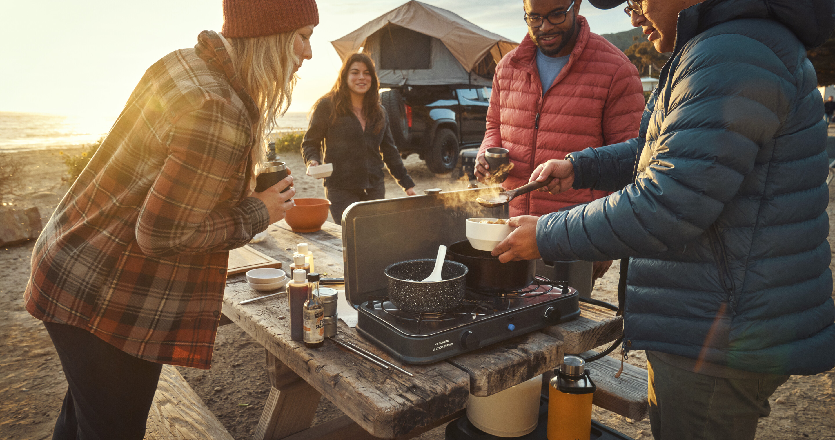 Family cooking outdoors with Dometic  Water Jug