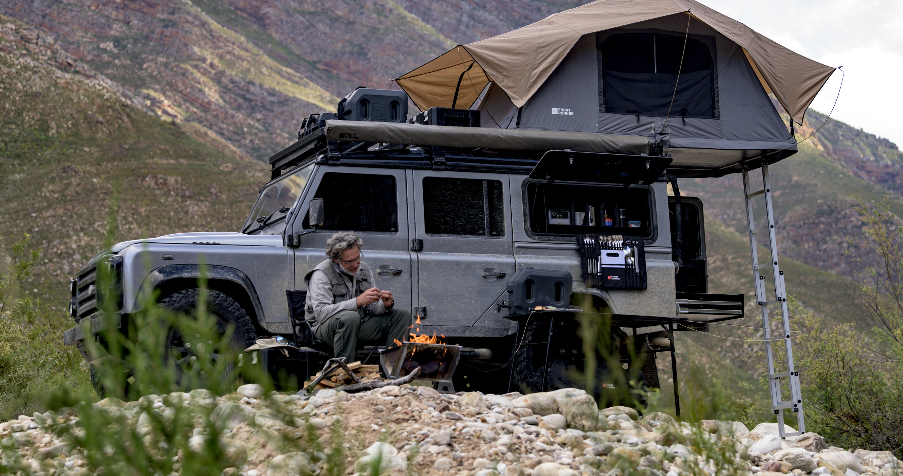 Overlanding Camp with a man sitting in a Front Runner camping chair