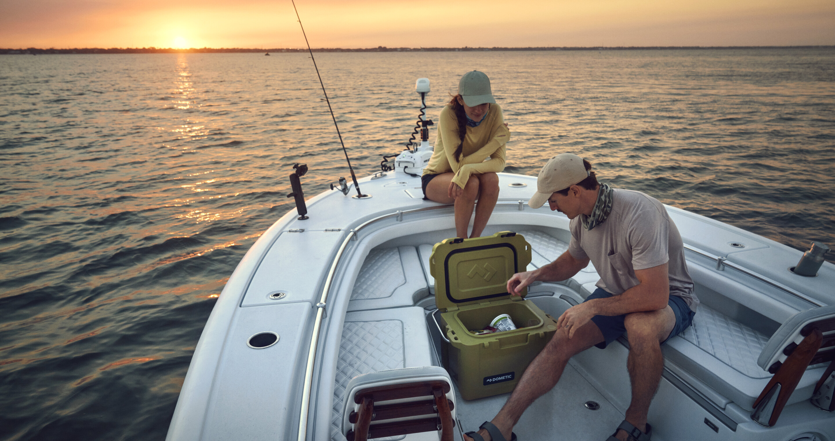 Two people on a boat with a cooler