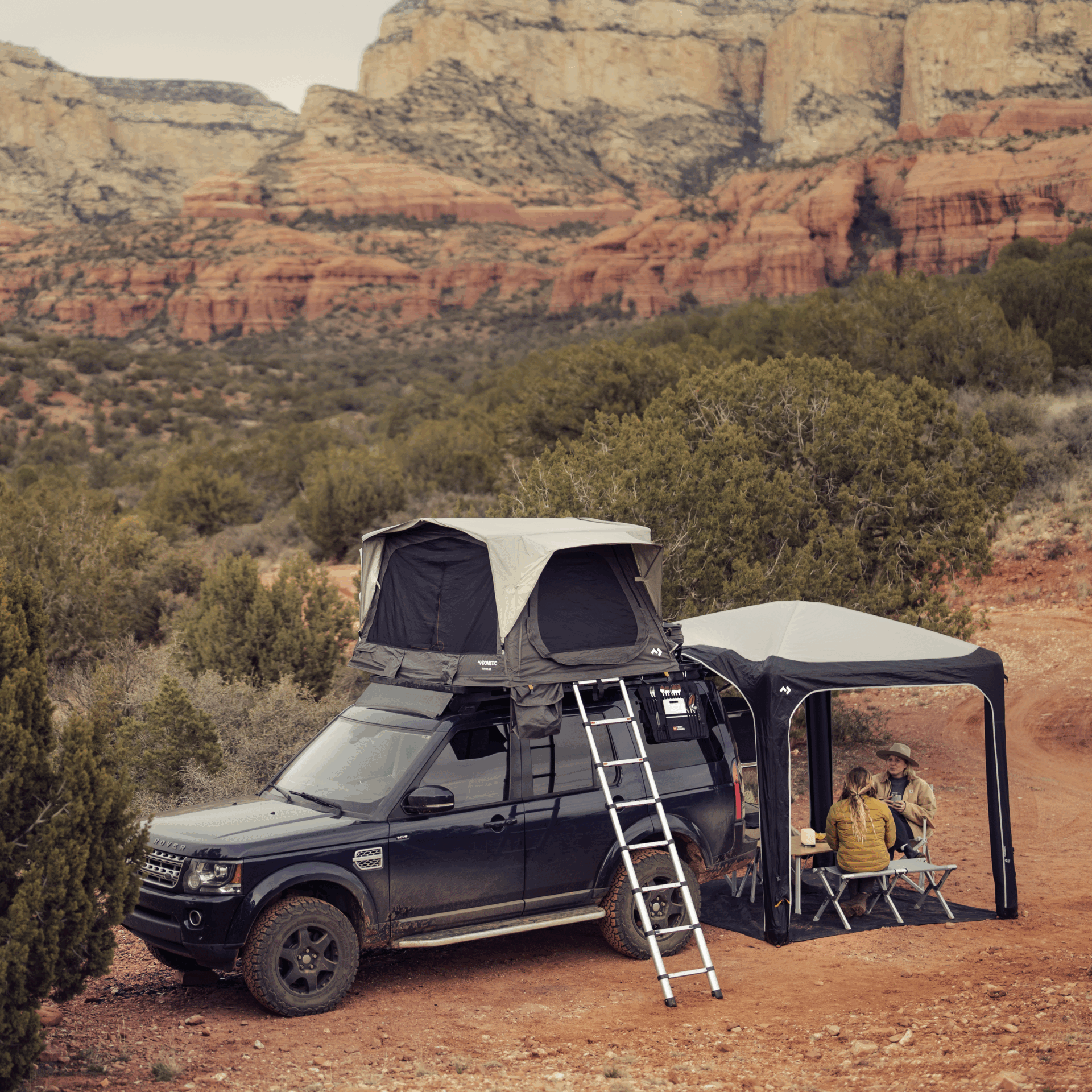Car with installed roof tent and shelter in a rocky landscape