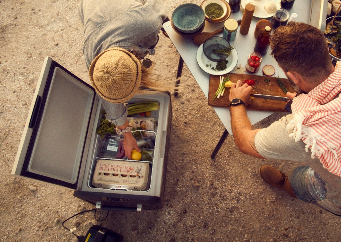 Woman taking groceries from CFX3 dual zone portable fridge