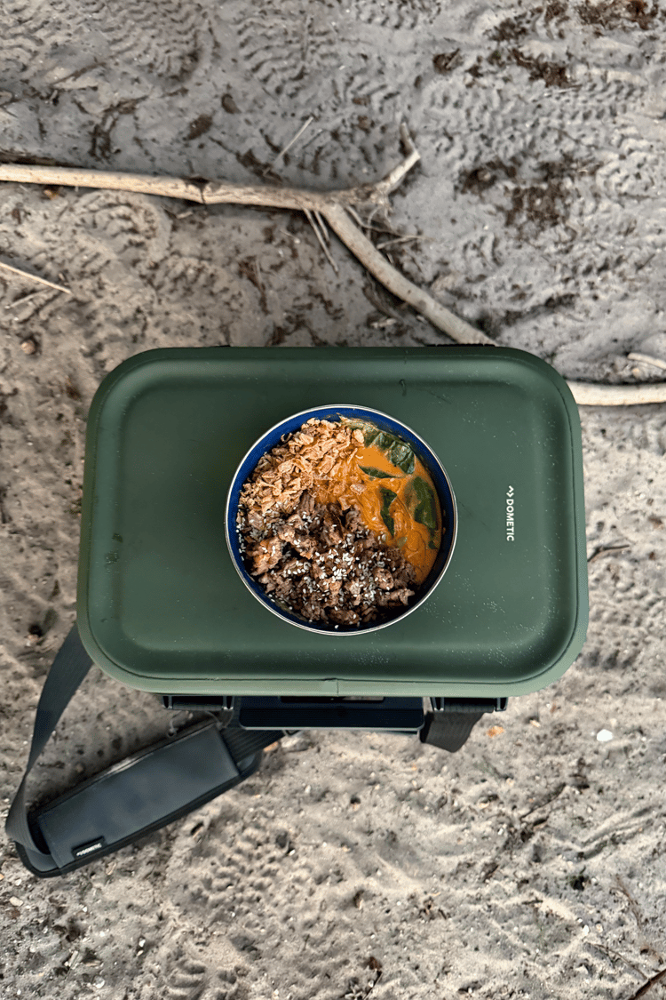 Harry cooks up a gourmet camp meal in the great outdoors, using his Dometic Recon Softside Cooler as a table. Perfect for camping, road trips, and outdoor adventures, the versatile cooler keeps food fresh while doubling as a practical campsite companion.