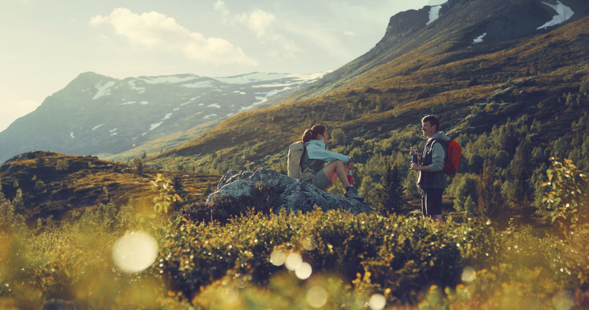 2 people taking a break from a hike in the mountains