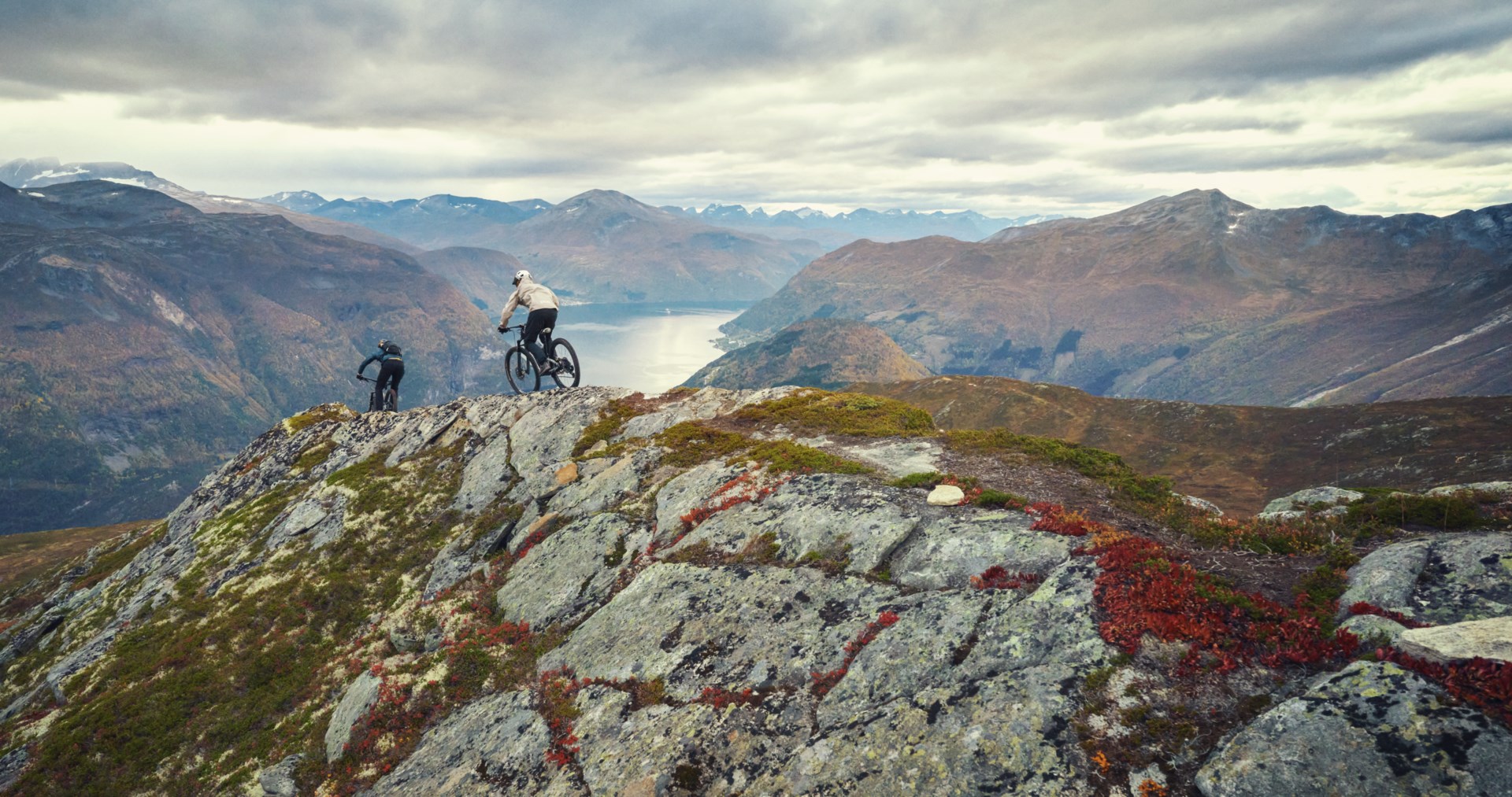 Two people mountain biking on top of a rocky mountain