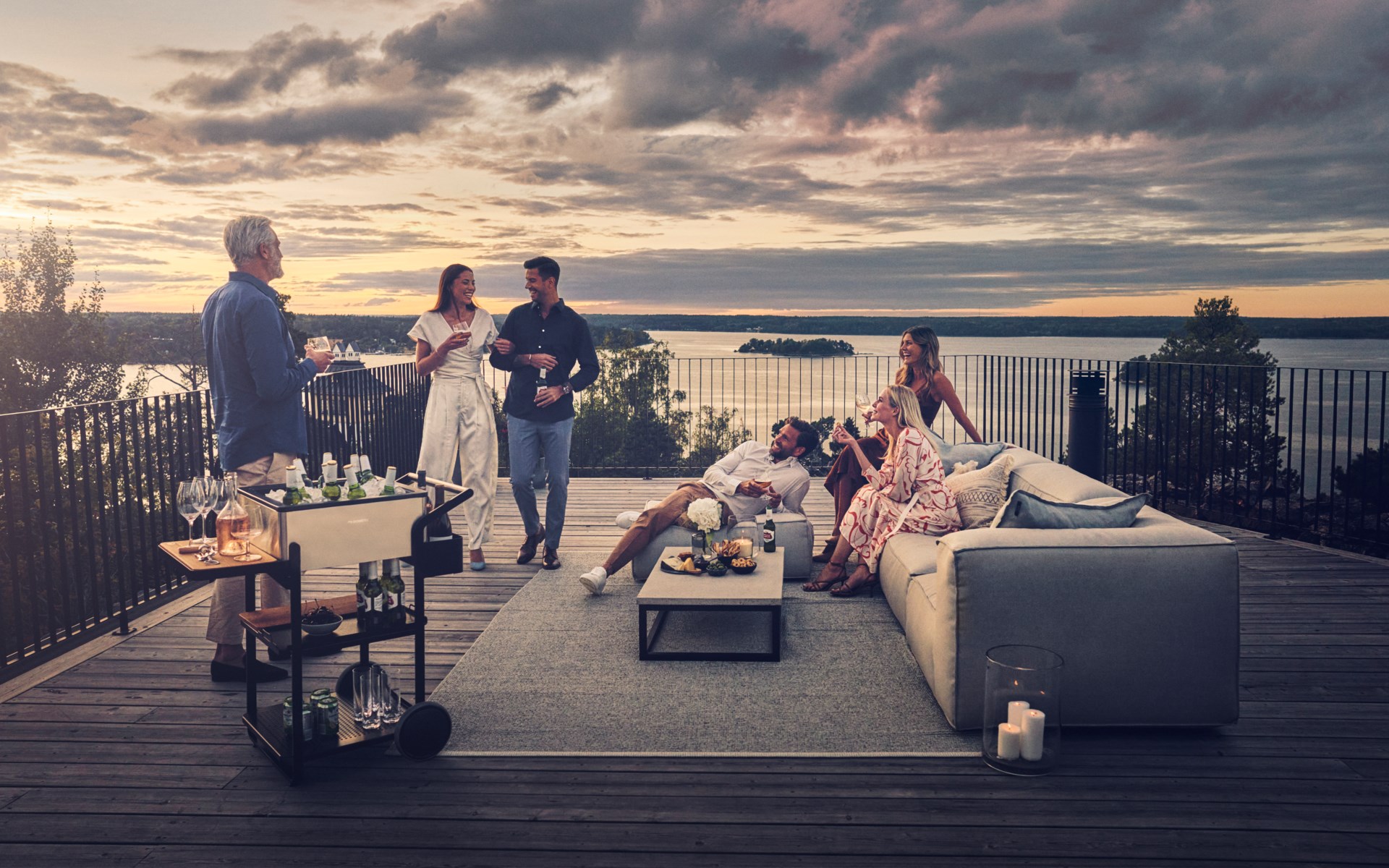 Group of friends sitting outside, enjoying beverages on the terrace